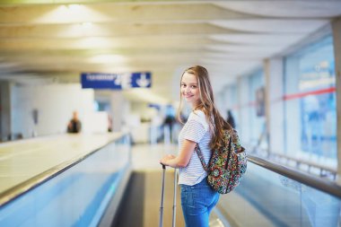Genç kadın travelator üzerinde Uluslararası Havaalanı