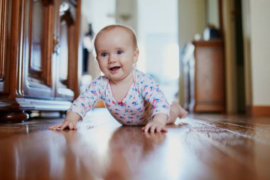 Bebek emeklemeyi öğreniyor. Yerde mutlu, sağlıklı bir çocuk var. Evde küçük bir çocuk var.