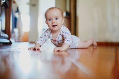 Bebek emeklemeyi öğreniyor. Yerde mutlu, sağlıklı bir çocuk var. Evde küçük bir çocuk var.