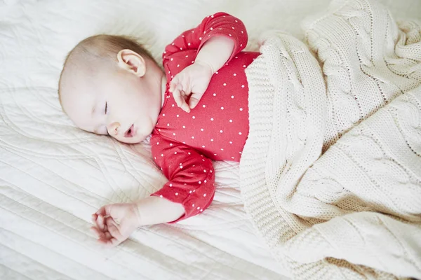 編んだ毛布の下で寝てる赤ん坊 ピンクの服を着た小さな子供が昼寝をしている 保育園の幼児 — ストック写真
