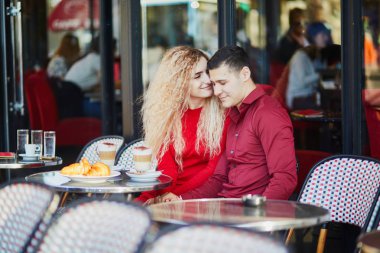 Güzel romantik çift Paris açık Cafe. Kahve içme ve Paris, Fransa'da restoranda kruvasan yemek turist