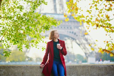 Güzel genç Fransız kadın Paris'te Eyfel Kulesinin yakınında bir Güz veya bahar gününde kahve içme