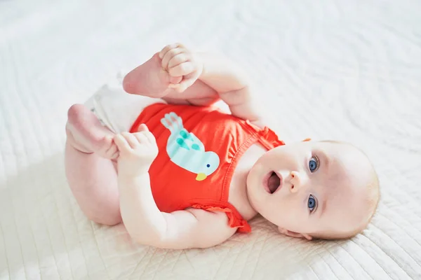 Linda Niña Acostada Boca Arriba Tocando Sus Pies Feliz Niño — Foto de Stock