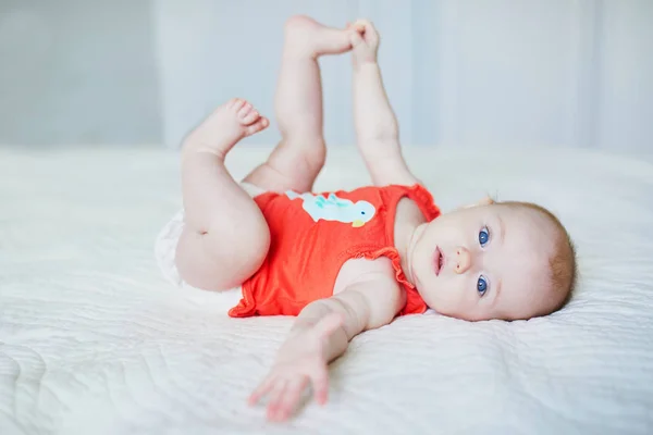 Roztomilá Holčička Ležící Zádech Dotýkající Nohou Šťastné Zdravé Dítě Doma — Stock fotografie