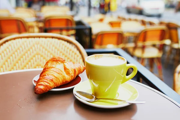 一杯の淹れたての熱いコーヒーとパリ フランスでパリの屋外カフェのテーブルで伝統的なフランス クロワッサン — ストック写真