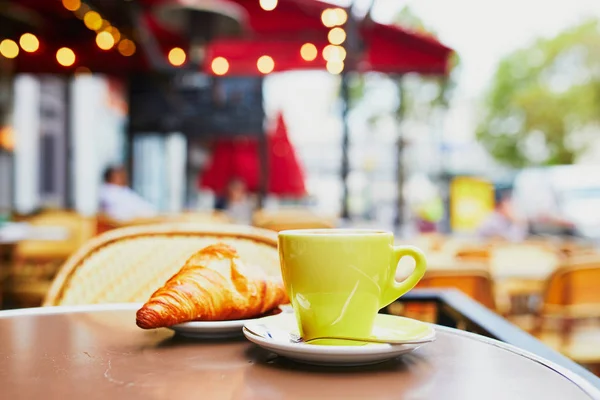 一杯の淹れたての熱いコーヒーとパリ フランスでパリの屋外カフェのテーブルで伝統的なフランス クロワッサン — ストック写真