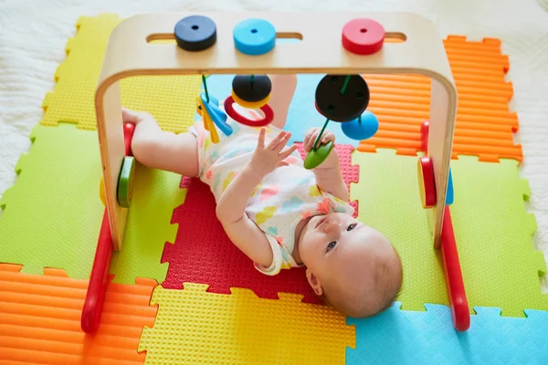 可爱的女婴在五颜六色的游戏垫子上玩玩具 快乐健康的孩子在地板上玩耍 — 图库照片