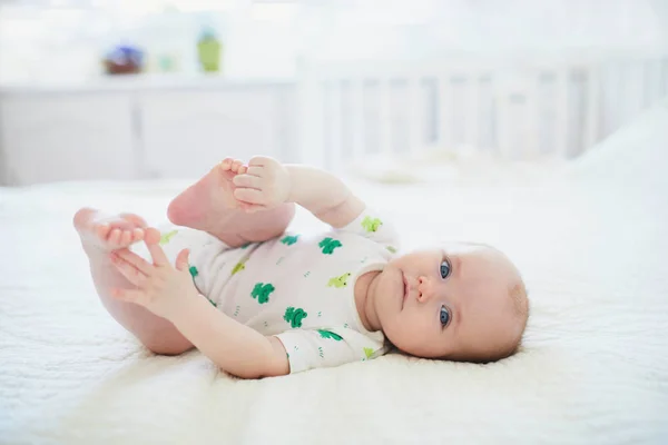 Linda Niña Acostada Boca Arriba Tocando Sus Pies Feliz Niño — Foto de Stock