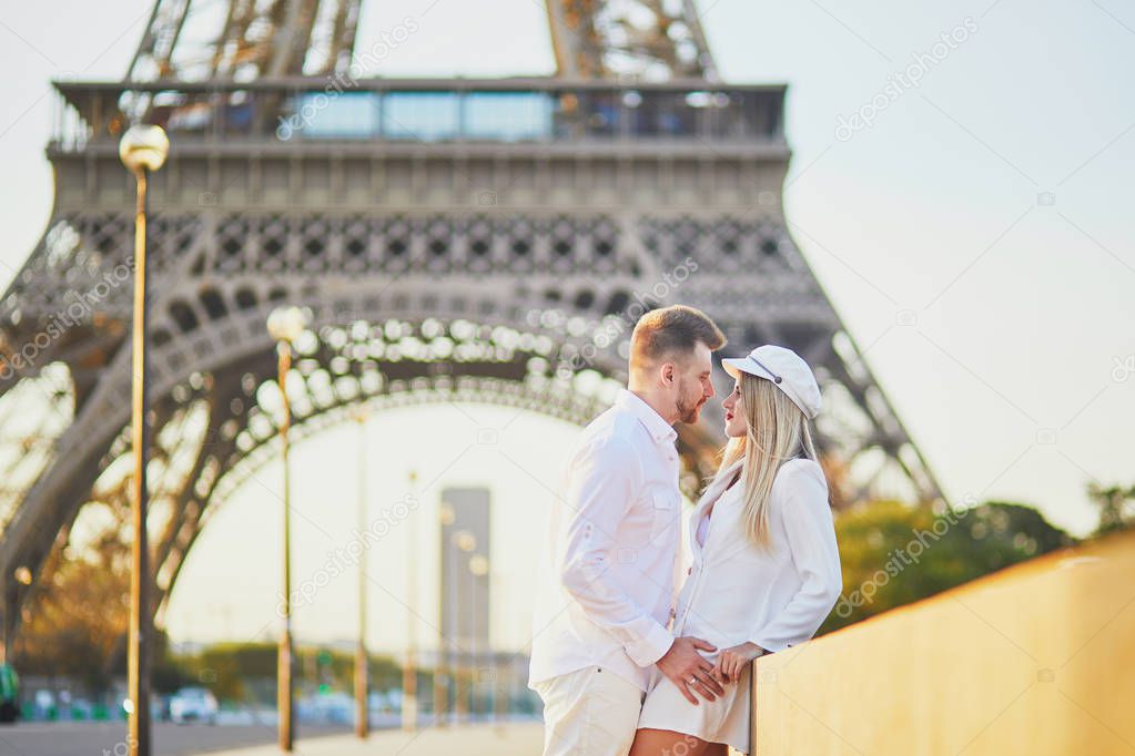 Romantic couple having a date near the Eiffel tower. Tourists in Paris enjoying the city