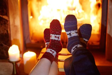 Şömine yakın sıcak çoraplı kadın ve erkek. İki ya da Noel kutlama kavramı için rahat romantik akşam