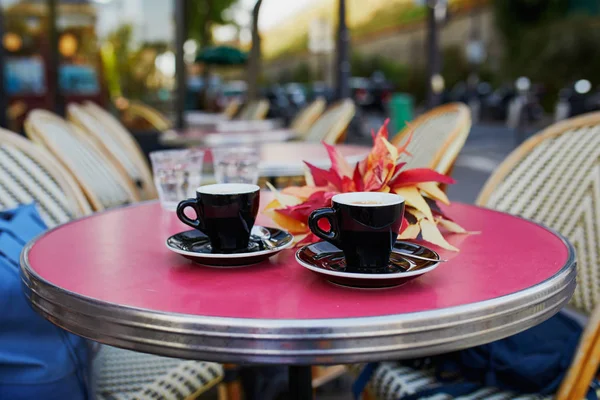 在法国巴黎传统的巴黎户外咖啡馆桌上 喝了两杯新鲜的热浓咖啡和秋叶 — 图库照片