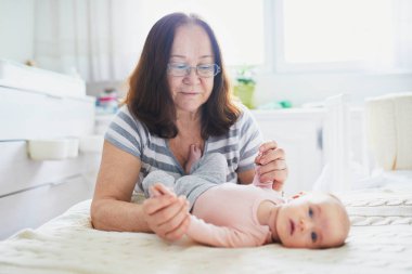 Mutlu üst düzey kadın kapalı küçük torunu ile. Büyükanne güneşli kreş çocuk ile