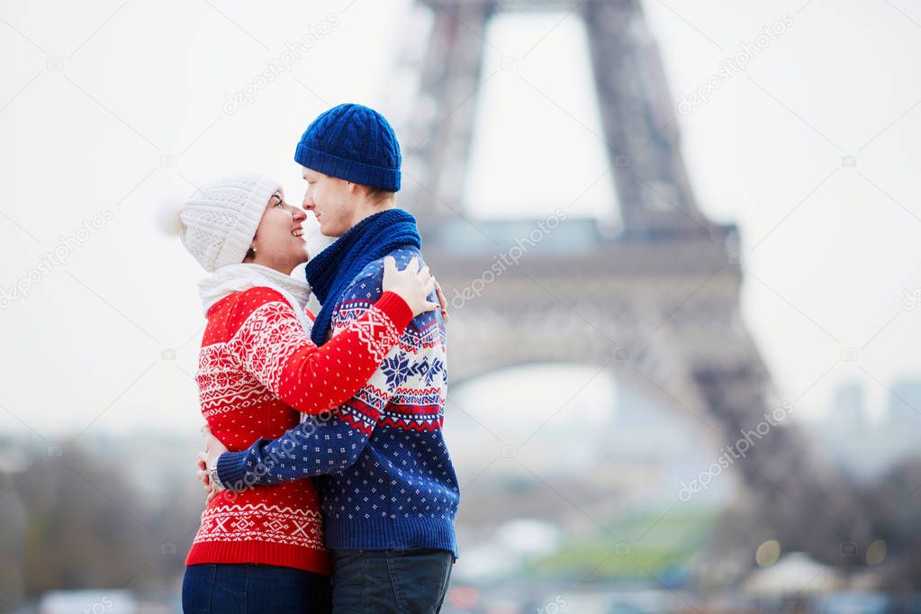 Happy couple near the Eiffel tower on a winter day. Trip to Paris during season holidays