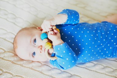 Sevimli bebek yatakta uzanıp gülümsüyor. Mutlu sağlıklı küçük çocuk gülüyor. Güneşli kreşte küçük bir çocuk.