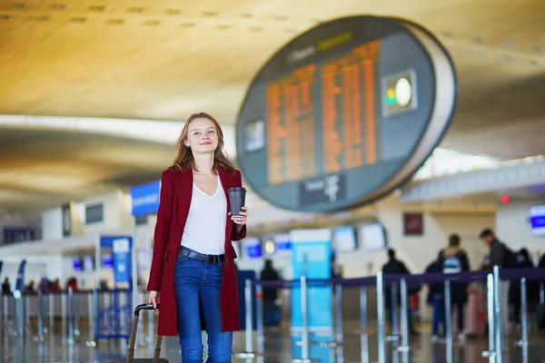 彼女の飛行の準備ができて荷物を持って歩いて国際空港で若い女性 — ストック写真