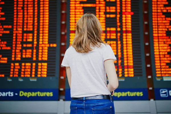 Uluslararası Havaalanı Uçuş Bilgileri Yakınındaki Bagajli Genç Kadında Görüntülemek — Stok fotoğraf