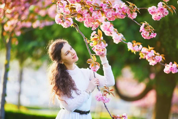 フランスのパリで桜の季節を楽しんでいる白いドレスで幸せな若い女 — ストック写真