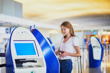 Uluslararası havaalanında self check-in yaparken genç kadın