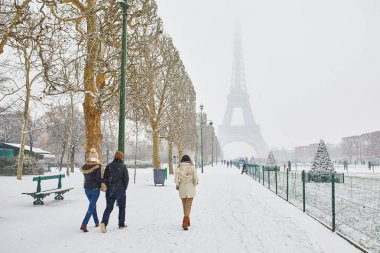 Eyfel Kulesi doğal görünümüne bir gün şiddetli kar yağışı ile. Paris karlı bir günde üzerinde yürüyen insanlar. Olağandışı hava koşulları Paris