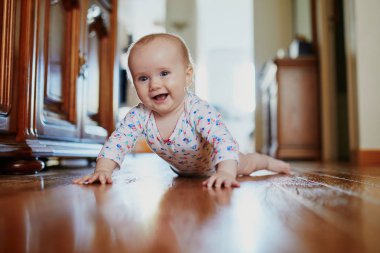 Bebek emeklemeyi öğreniyor. Yerde mutlu, sağlıklı bir çocuk var. Evde küçük bir çocuk var.