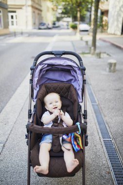 Bebek arabasındaki bebek renkli oyuncaklar kızla. Çocuk arabası küçük çocuk. Bebek çocukta açık havada arabasını