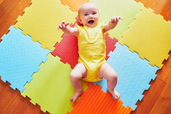 Happy Uśmiechnięta Dziewczynka Leżąca Kolorowe Maty Zabawy Podłodze Widok Góry — Zdjęcie stockowe