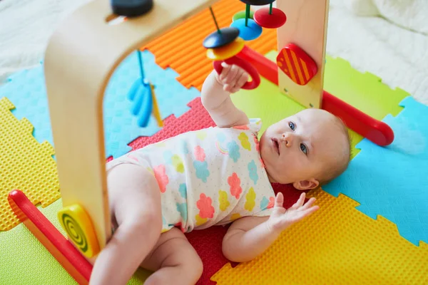 可爱的女婴在五颜六色的游戏垫子上玩玩具 快乐健康的孩子在地板上玩耍 — 图库照片
