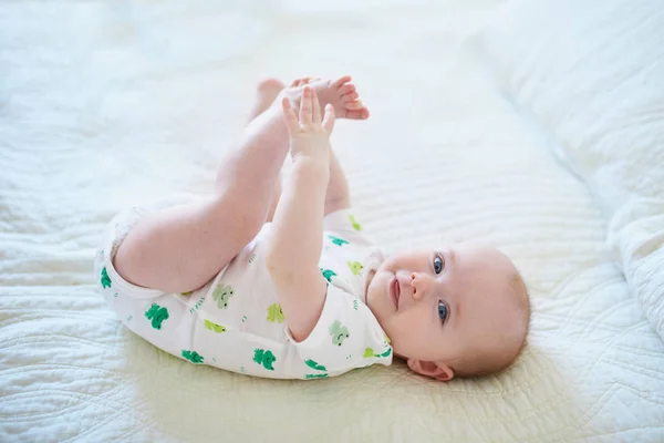Roztomilá Holčička Ležící Zádech Dotýkající Nohou Šťastné Zdravé Dítě Doma — Stock fotografie