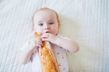 Altı aylık bebek geleneksel Fransız ekmeği (baget) yiyor. Katıları yeni doğmuş çocuklarla tanıştırmak. Sütten kesilme konsepti
