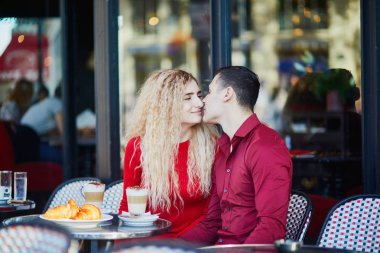 Güzel romantik çift Paris açık Cafe. Kahve içme ve Paris, Fransa'da restoranda kruvasan yemek turist