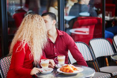 Güzel romantik çift Paris açık Cafe. Kahve içme ve Paris, Fransa'da restoranda kruvasan yemek turist