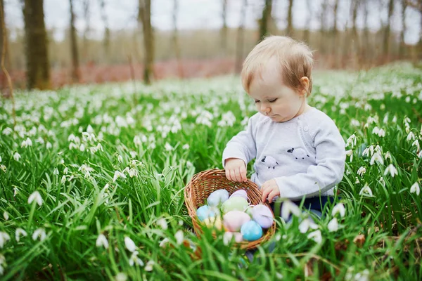 Linda niña de un año jugando a la caza de huevos en Pascua —  Fotos de Stock