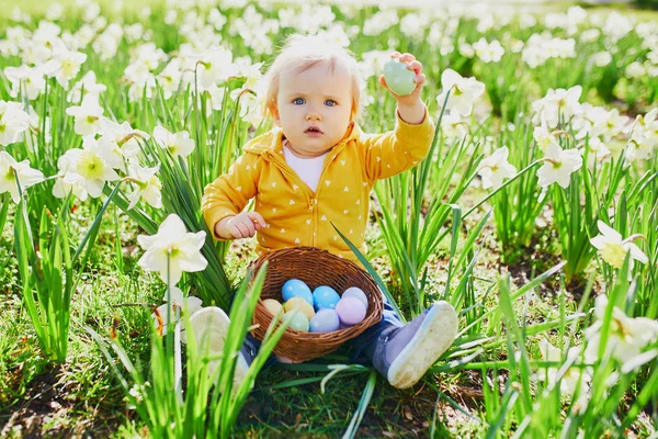 Linda niña de un año jugando a la caza de huevos en Pascua —  Fotos de Stock