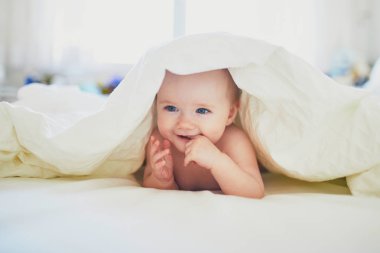 Yatakta oynayan tatlı küçük kız.