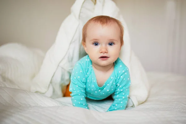 Söt liten flicka leker med kuddar på sängen — Stockfoto