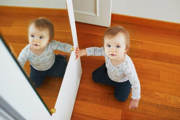 Niña jugando con su reflejo en el espejo —  Fotos de Stock