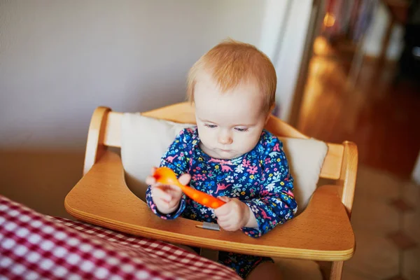 Söt liten flicka leker med sked i köket — Stockfoto