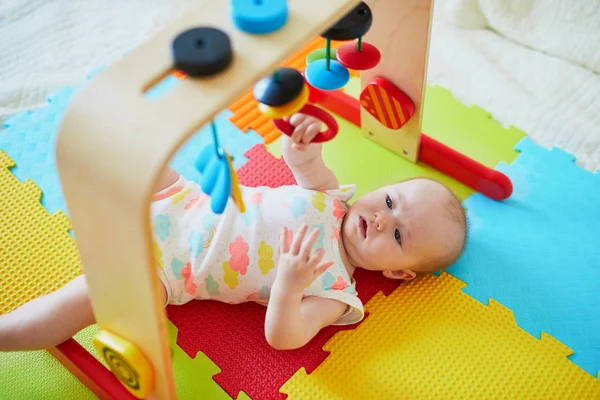小女孩在五颜六色的游戏垫子上玩玩具 — 图库照片