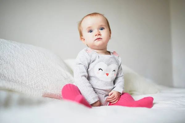 Baby girl sitting on bed — Stock Photo, Image