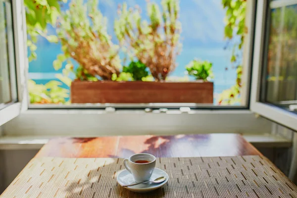 Cup of espresso coffee near the window — Stock Photo, Image