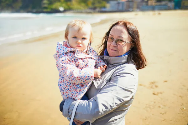 Grandmother and granddaughter enjoying Atlantic ocean on the beach — Stock Photo, Image