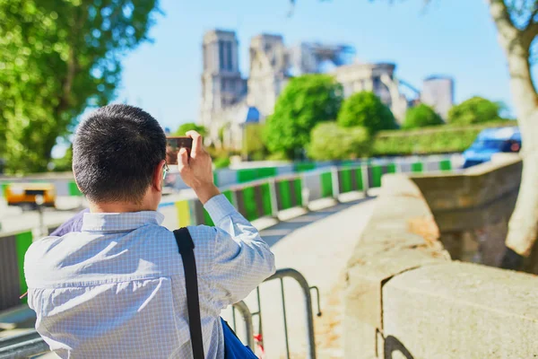 Tourist taking photos of Notre Dame cathedral without roof and spire — Stock Photo, Image