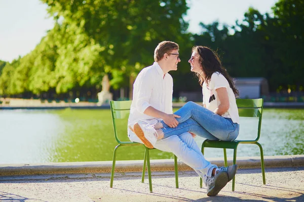 Happy romantic couple in Paris, sitting on traditional green metal chairs in Tuileries garden — Stock Photo, Image