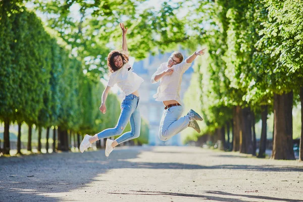 Feliz pareja romántica en París, saltando en el jardín de las Tullerías — Foto de Stock