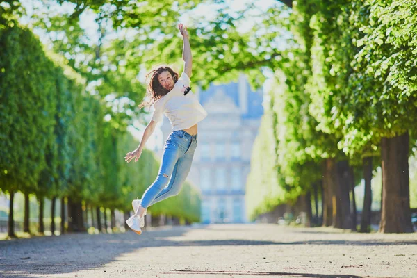 Boldog fiatal lány Párizsban, ugrás a Tuileriák kert — Stock Fotó
