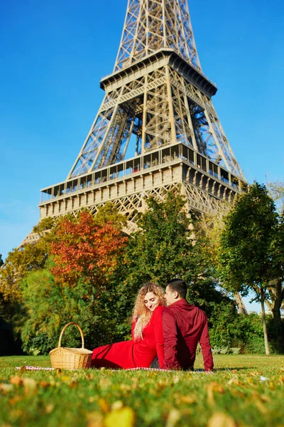 Romantic couple having picnic on the grass near the Eiffel tower — Stock Photo, Image