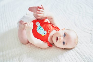 Sırtüstü yatıp ayaklarına dokunan tatlı bir kız.