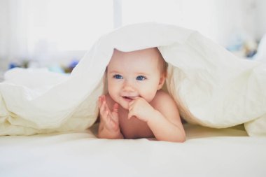 Yatakta oynayan tatlı küçük kız.