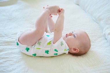 Sırtüstü uzanmış tatlı bir kız bebek.