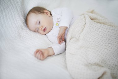 Örgü battaniye altında beşik te uyuyan sevimli kız bebek
